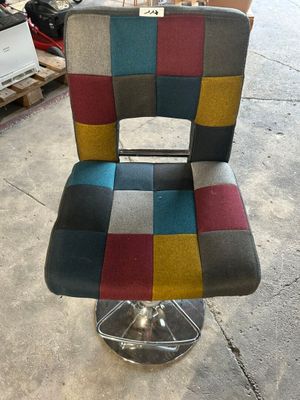 a chair that has a colorful seat on it in a warehouse