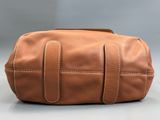 une image représentant une trousse de toilette en cuir marron sur fond gris
