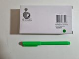 a green pen next to a white box with a barcode on it
