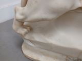 a white marble sculpture of a horse on a bench