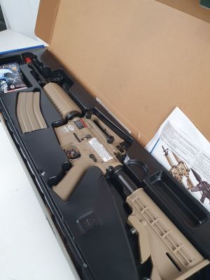 une boîte ouverte contenant un fusil, posée sur une table