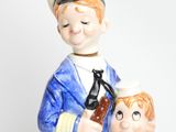 a figurine of a sailor and a boy holding a bottle