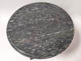 a round table with a black marble top on a white background