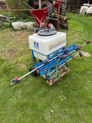a close up of a tractor with a sprayer in the grass