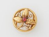 an image of a gold broochle with a flower and pearls