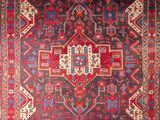 a red and blue rug with an ornate design