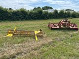 deux outils agricoles dans un champ près d'une haie