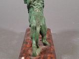 statue of a lion on a wooden base on a gray background
