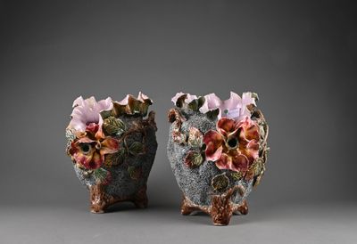 pair of ceramic vases with flowers on them on a gray surface