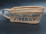 an image of a woven basket bag with a blue writing on it