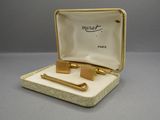 an image of a pair of gold cufflinks in a case