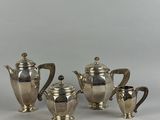 a silver plated tea set with four cups and a saucer
