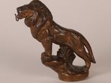 bronze statue of a lion on a rock with a hook in its mouth