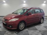 une photo d'un monospace Mazda rouge garé dans un garage