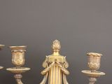 three candles are sitting on a wooden table with a gray wall in the background