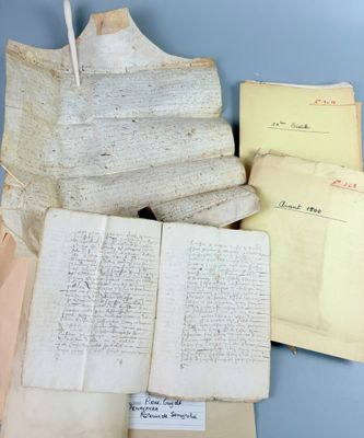 several old papers and a pen sit on a blue surface