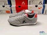 grey and red sneakers are on a white surface in front of boxes