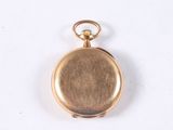 a gold colored pocket watch with a chain on a white surface