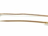 pair of gold tone hair pins with white stones on them