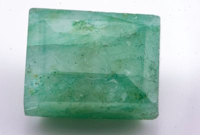 gros plan d'une pierre d'émeraude verte sur une surface blanche