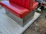 a red leather couch sitting on a platform in a yard