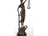 une statue en bronze représentant une femme tenant une balance et une épée
