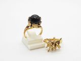 l'image d'une bague en or ornée d'une pierre noire