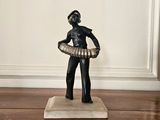 une statue représentant un homme tenant un hula-hoop sur un plancher en bois