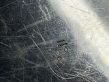 a close up of a piece of metal that has some scratches on it