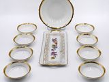 a group of porcelain bowls and plates with gold rims