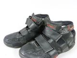 une paire de chaussures noires rehaussées de touches rouges sur fond blanc