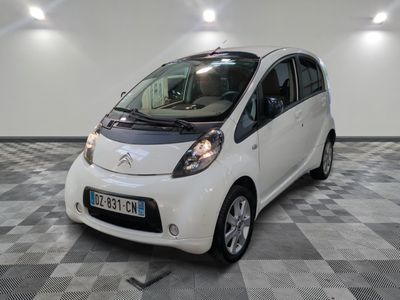 une petite voiture blanche garée sur un sol en damier