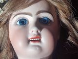 a close up of a doll with blue eyes