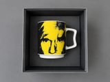 a yellow and black mug with a picture of a man ' s face on it