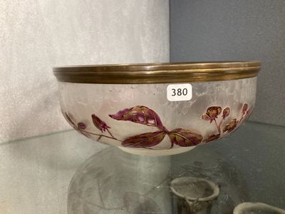 a glass bowl sitting on a glass table with a gold rim