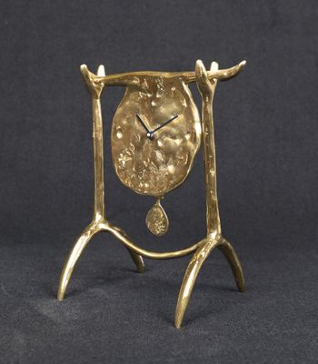 gold plated clock on stand on black background with black background