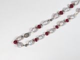 a white and red beaded necklace on a white table