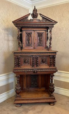 une étagère en bois ornée de sculptures, dans une pièce