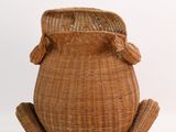 a small wicker frog sitting on a white surface