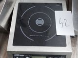 une plaque de cuisson noire et argentée sur laquelle est posée une pancarte