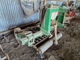 une machine verte qui est à l'arrêt dans la boue