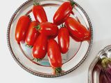 a plate of tomatoes and an eggplant on the table