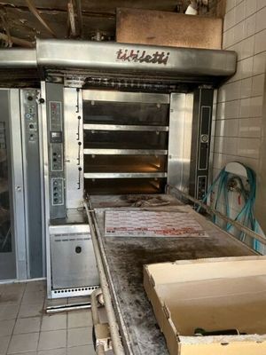 a box of pizza sitting on a counter in front of an oven