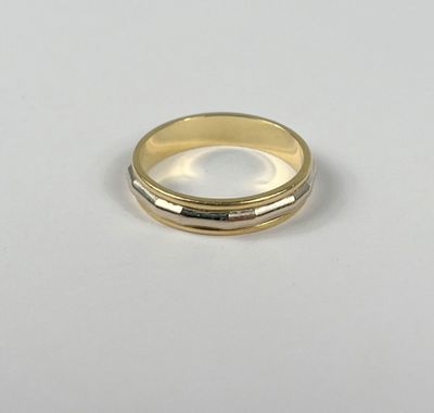 gros plan d'une bague en or sur une surface blanche