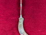 an old silver spoon sitting on top of a red cloth