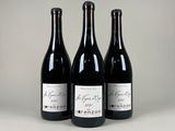 trois bouteilles de vin sont alignées sur une table