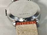 a close up of a watch on a white surface