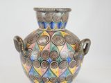 a vase with a colorful design on it sitting on a table