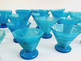 a lot of blue glass cups sitting on a table
