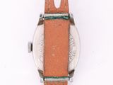 a close up of a watch on a white surface